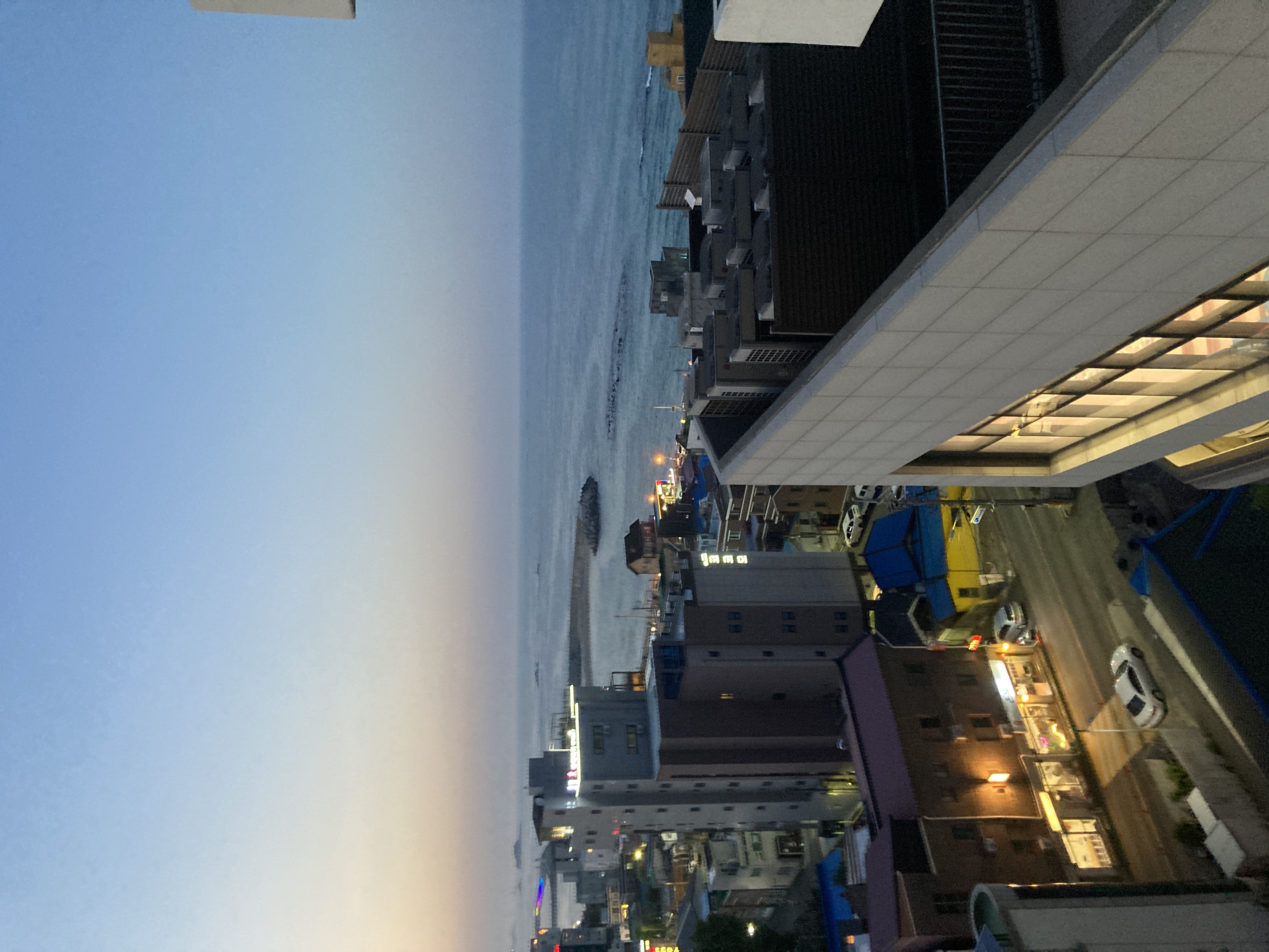 해질 무렵 창 너머로 보이는 속초 바다와 항구 마을